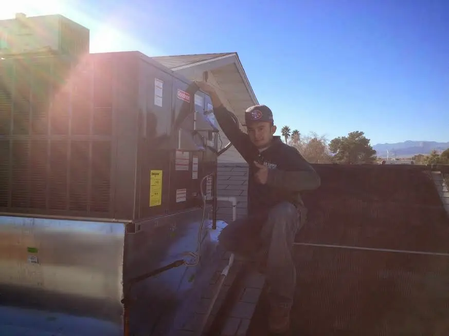 HVAC technician performing Air Duct Cleaning on a rooftop unit in San Rafael